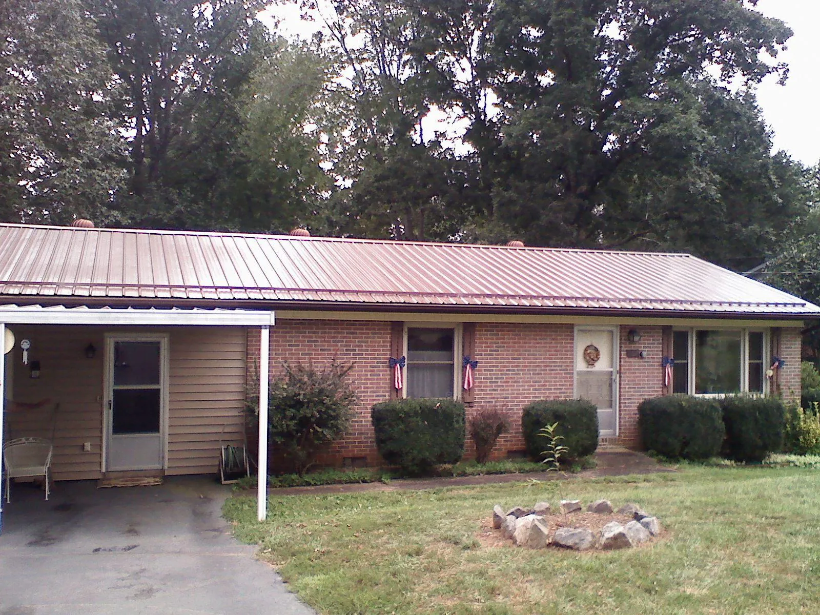 Bronze metal roof and carport on a brick ranch home — Roof Repair work by our crew in Elk